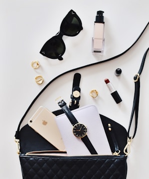 women's sunglasses and black bag with watch and iPhone 6