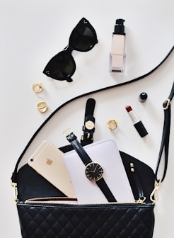 women's sunglasses and black bag with watch and iPhone 6