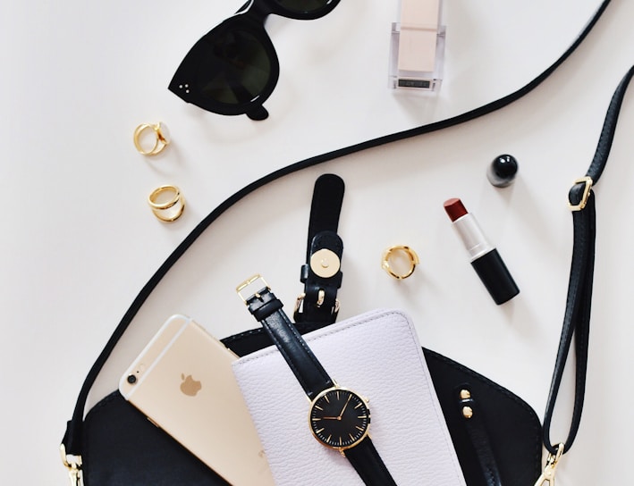 women's sunglasses and black bag with watch and iPhone 6