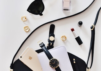 women's sunglasses and black bag with watch and iPhone 6