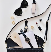 women's sunglasses and black bag with watch and iPhone 6