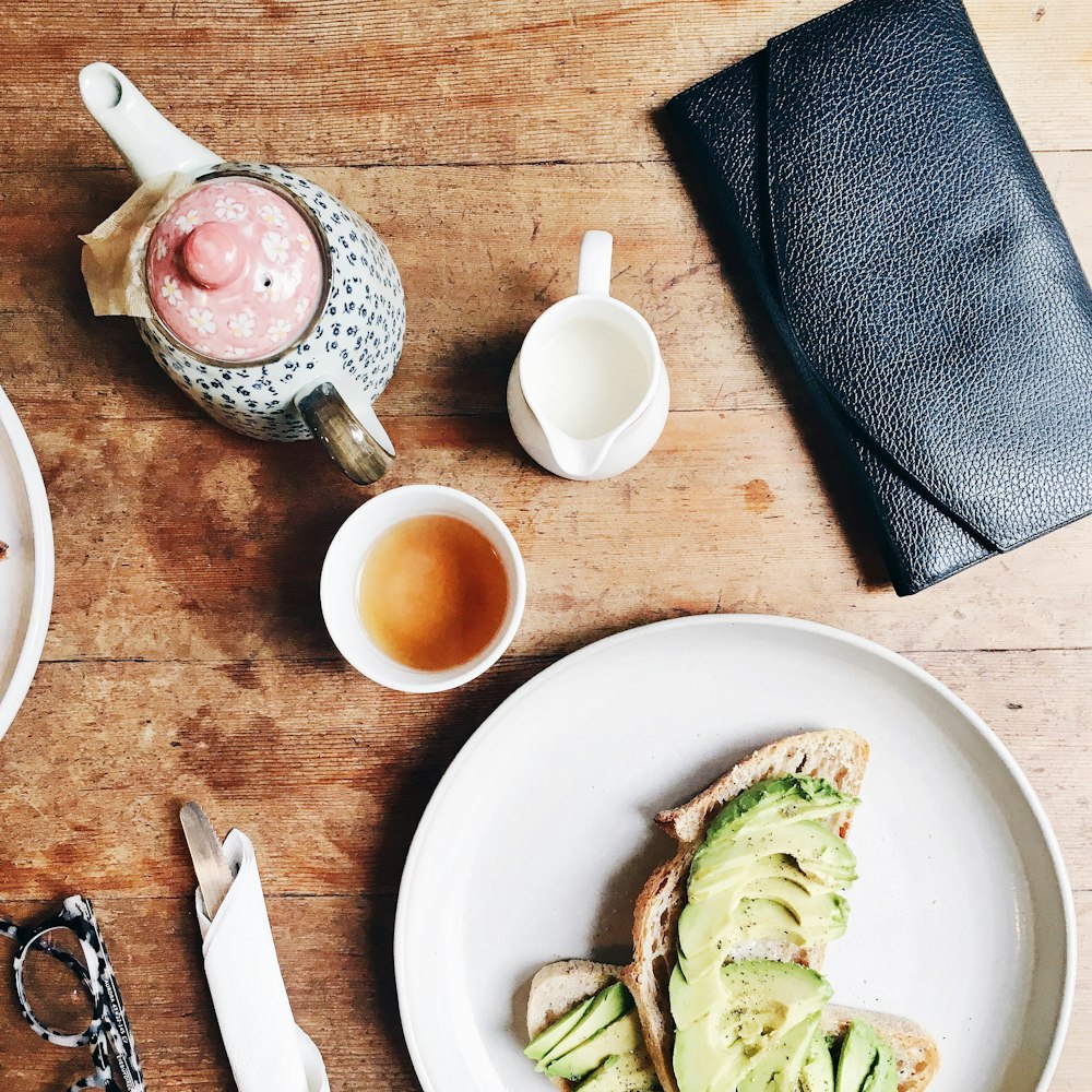 black leather long wallet beside plate