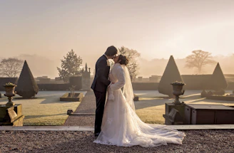 A romantic aerial shot of a wedding ceremony in a lush garden at golden hour.