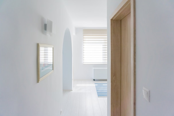 A minimalist hallway decorated with tall pampas grass and subtle animal wall accents.