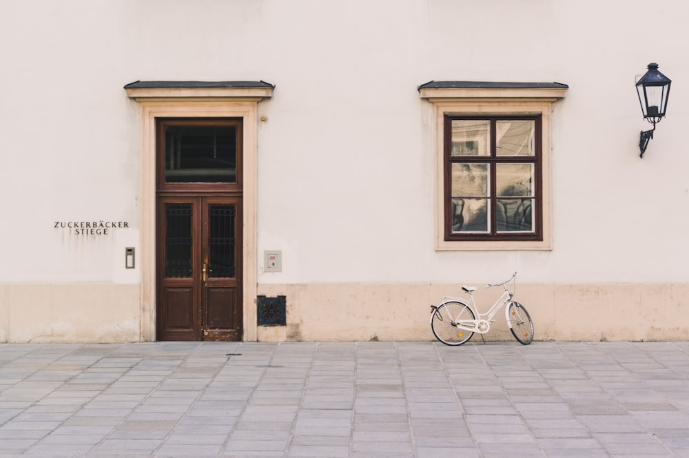 white cruiser bike beside white structure