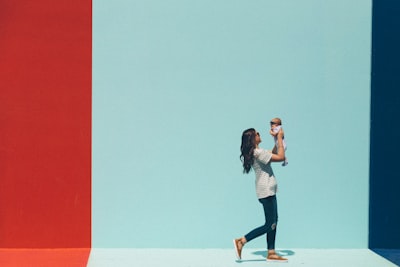 woman carrying baby while walking day google meet background