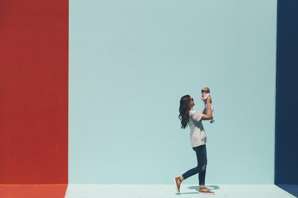 woman carrying baby while walking