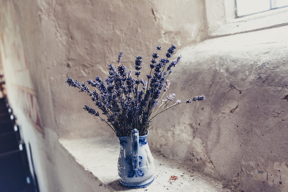 blue flowers in vase on window sill