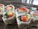 Close-up of neon pink and cyan sushi rolls with glowing accents.