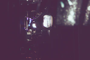 A dimly lit film projector casting a soft glow in a dark screening room