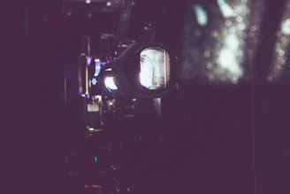 Close-up of a compact projector with Australian landscape reflected on its lens.