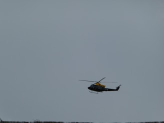 A stealth helicopter flying over a dark, foggy landscape at night.