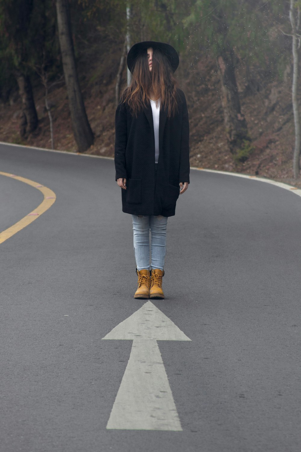 Mujer de pie en el camino de asfalto