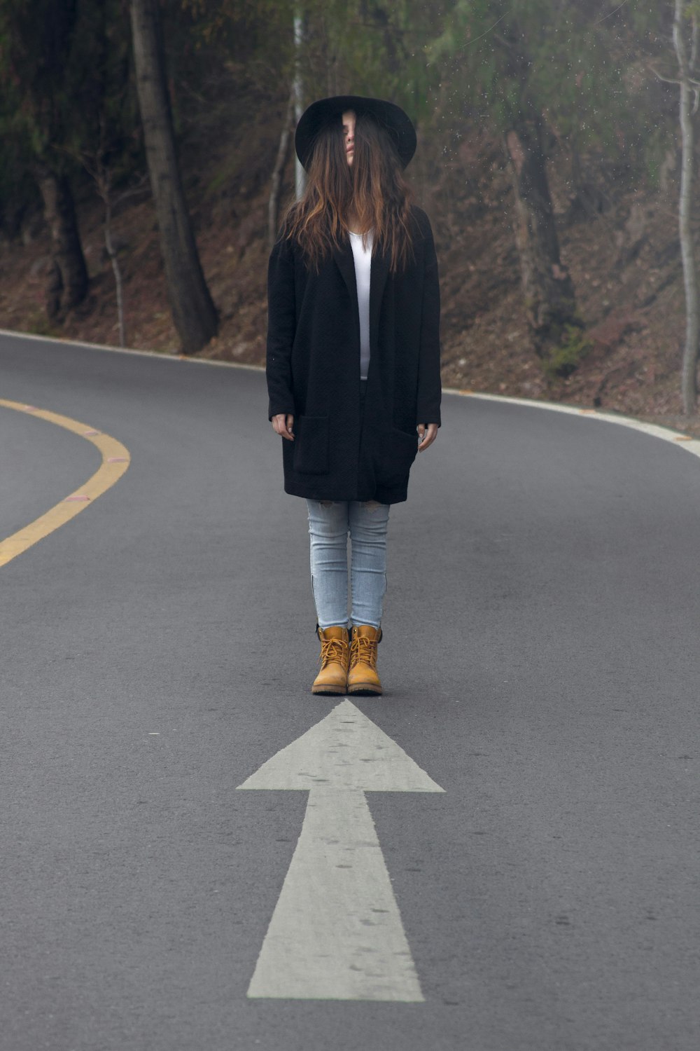 アスファルト道路に立つ女性