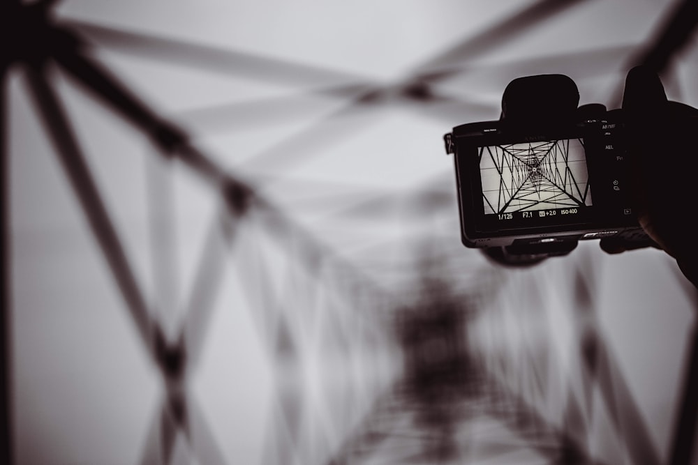 personne tenant le pont de capture de l’appareil photo reflex numérique