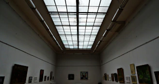 A serene gallery space with terracotta-toned lighting highlighting contemporary art.