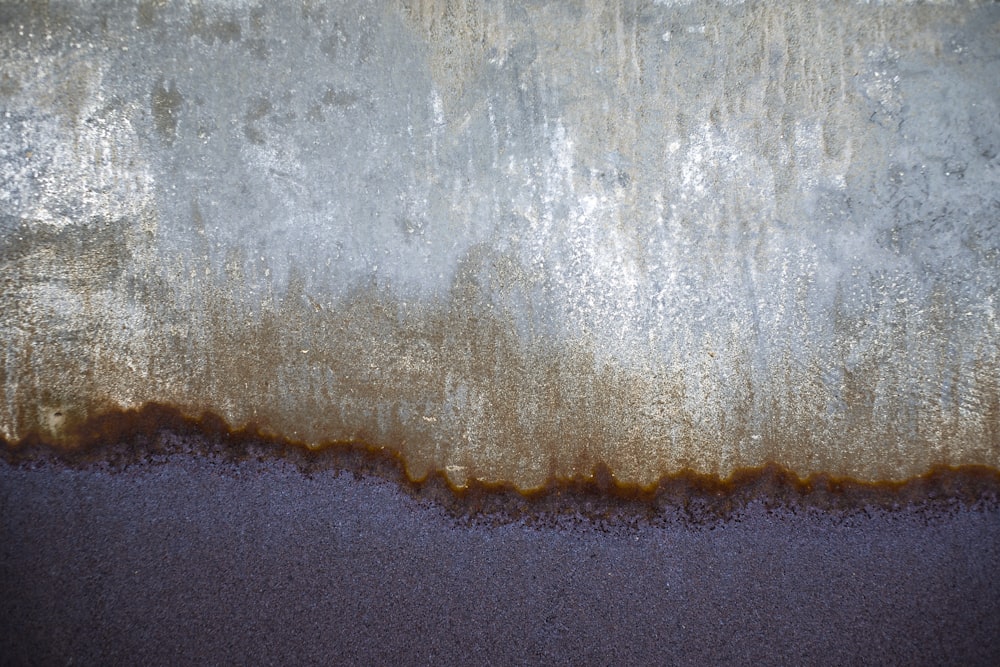 Un primer plano de una pared con pintura marrón y blanca