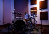 Recording equipment set up beside a drum kit, capturing the creation of original soundtracks.