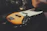 Close-up of a sunburst vintage electric guitar resting on a wooden floor.
