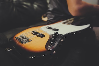 Close-up of a vintage electric guitar resting on a dark stage floor.