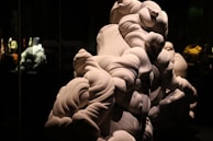 A sculptural ceramic piece with flowing organic shapes displayed against a neutral backdrop.