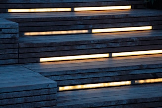 Wooden stairs with built-in yellow lighting along each step create a modern, ambient appearance.
