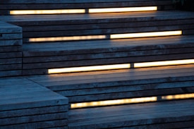 Wooden stairs with built-in yellow lighting along each step create a modern, ambient appearance.