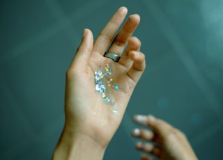 person showing hands with glitters