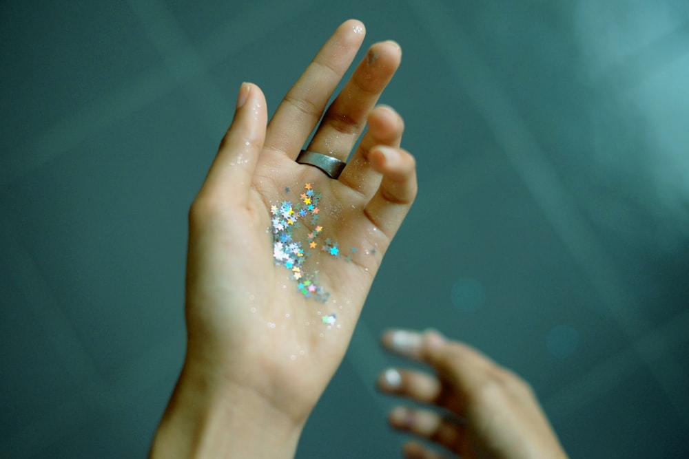 person showing hands with glitters