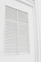 Sleek black metal louvered shutters reflecting soft ambient light