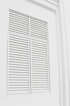 Sleek black metal louvered shutters reflecting soft ambient light