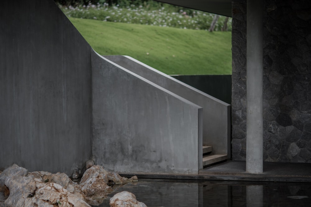 a concrete structure with a green field in the background