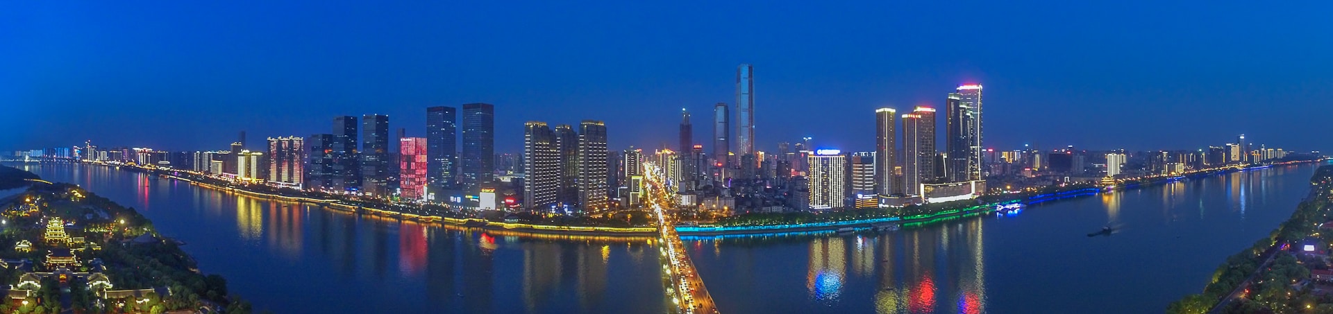 A panoramic view of the rooftop sky bar at Fox Garden New showcasing the city skyline at night with colorful lights.