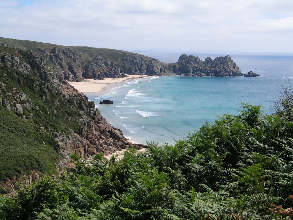 seashore near mountain during daytime