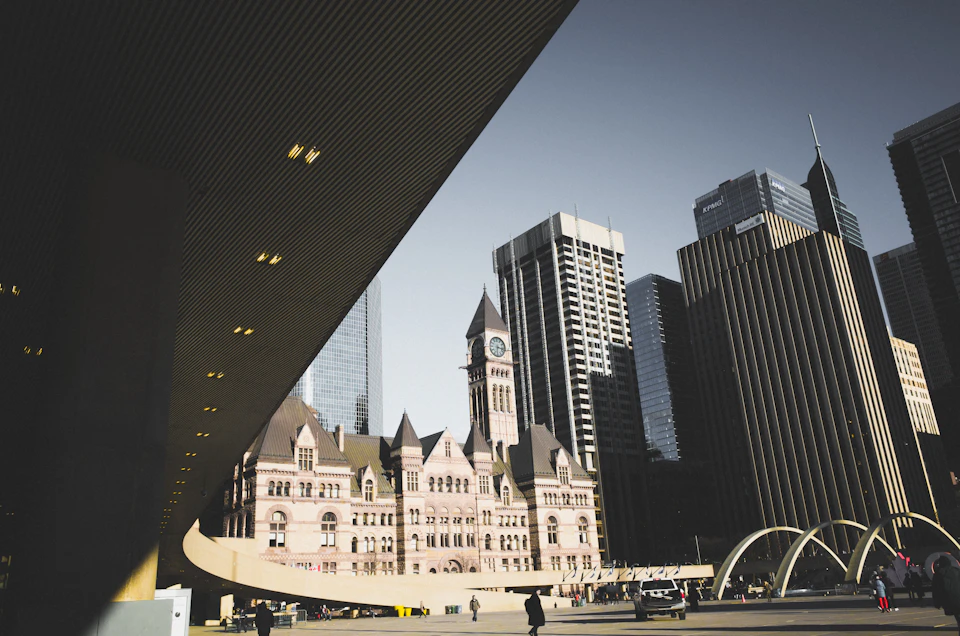 Bustling city scene features tall buildings and large clock tower dominating the skyline prominently