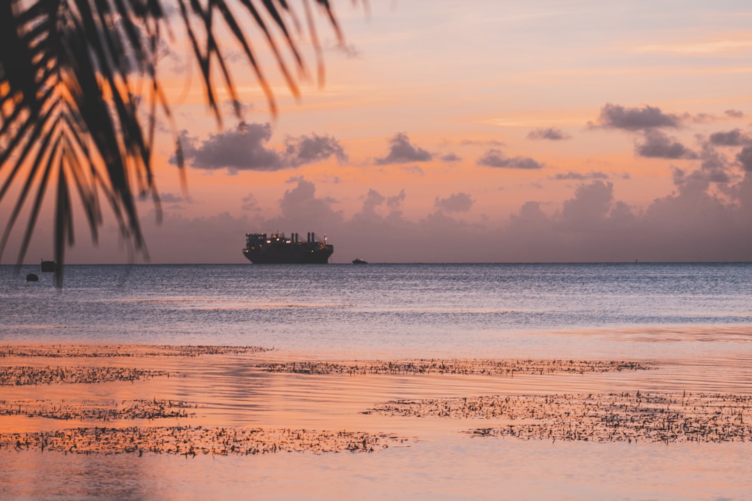 silhouette of ship on body of water during golden hour