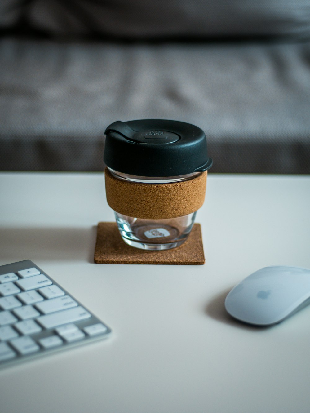 covered jar between Magic Mouse and Keyboard on desk