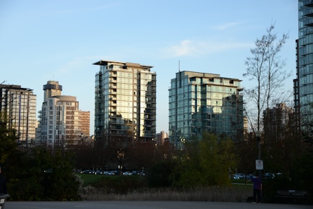 Modern high-rise buildings reflecting sunlight in a bustling cityscape.