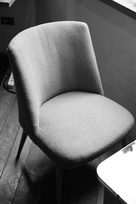 A cozy modern chair with soft cushions near a window