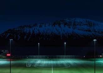 A vibrant graphic showing a mountain peak with football icons and team logos around it.