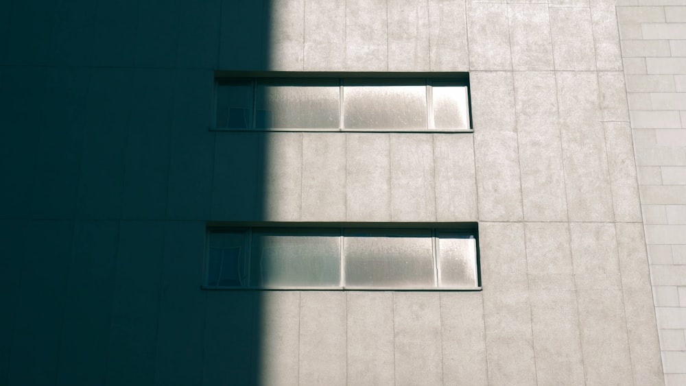 Concrete building with horizontal windows half in shadow