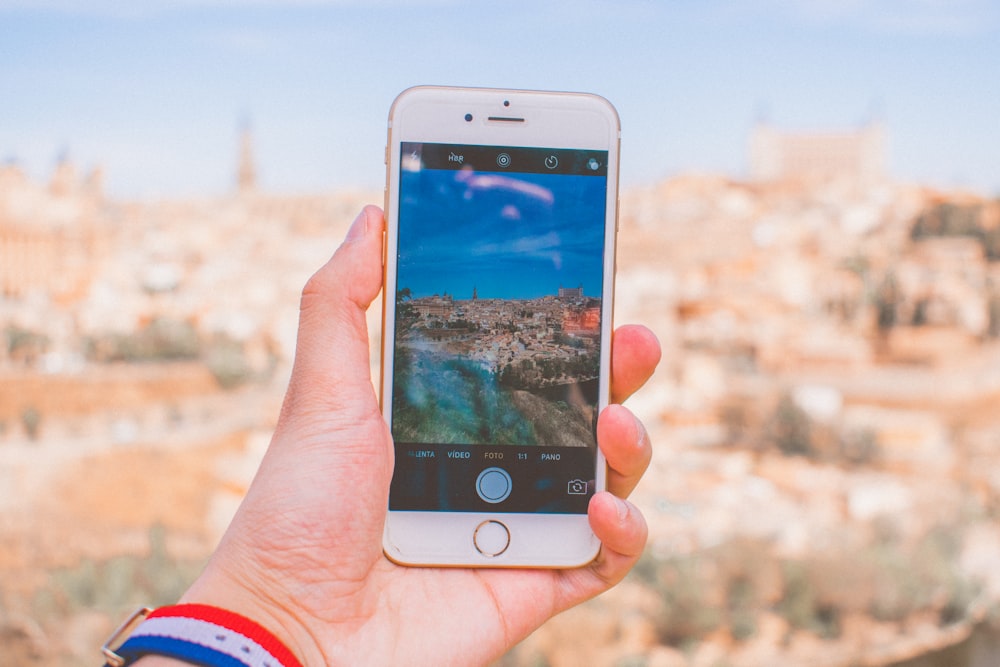 person holding gold iPhone 6 during daytime