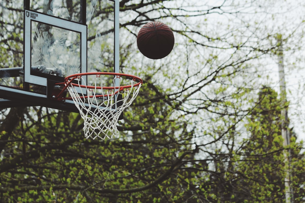 Fotografia de lapso de tempo de bola prestes a atirar no aro de basquete