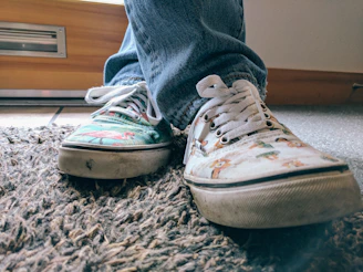 Close-up of feet in colorful sneakers moving rhythmically on a wooden floor.