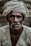 man wearing gray turban smoking cigarette in closeup photography