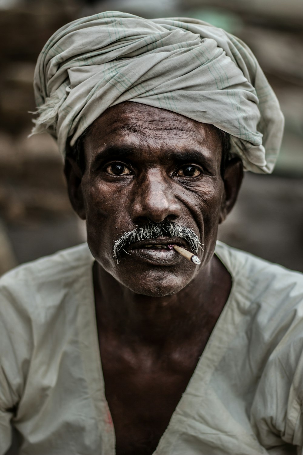 Mann mit grauem Turban raucht Zigarette in Nahaufnahme
