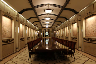 A tidy conference room with elegant dark green walls and golden decorative touches.