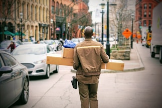 man in brown jacket beside car