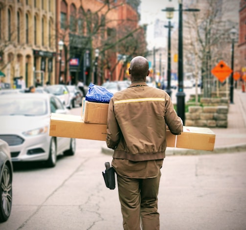 man in brown jacket beside car