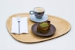 Elegant wooden tray holding coffee cups and pastries with natural wood grain visible